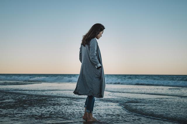 eine Dame die am Meer spaziert