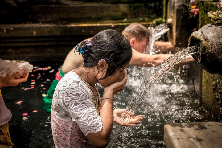 Eine Dame und ein Herr trinken Wasser aus dem Brunnen