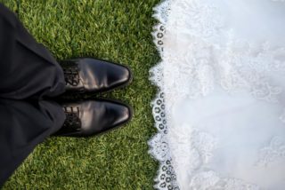 Die Schuhe von dem Bräutigam und das Kleid von der Braut