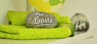 Gästehandtuch in Grün mit einem Dekor Stein
