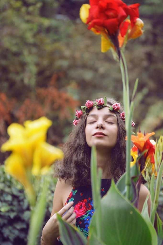 Eine Dame im Blumengarten mit einem Blumenkranz auf dem Kopf