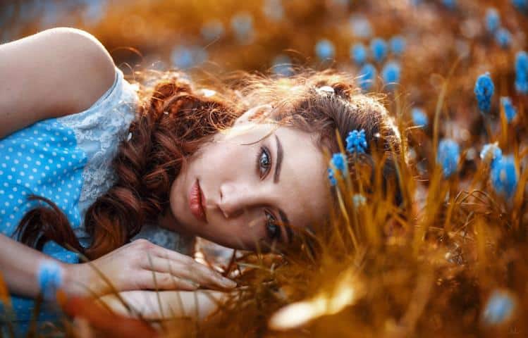 Die Frau im hellblauen Kleid und blauen Blumen