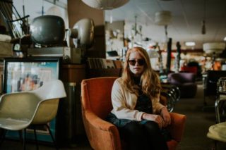 Eine Frau die mit einer Sonnenbrille im Cafe sitzt